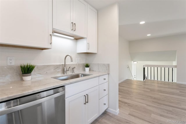 kitchen featuring dishwasher, sink, light wood-type flooring, light stone counters, and white cabinetry