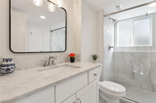 bathroom featuring vanity, toilet, and a shower with door