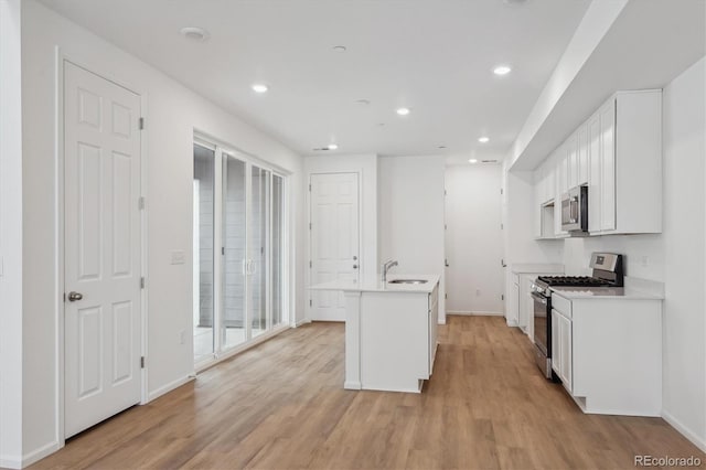 1242 Penner Dr, Erie, CO 80026 - kitchen featuring white cabinets, light wood-style floors, light countertops, and stainless steel appliances