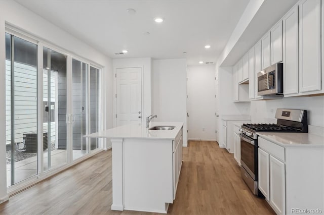 1242 Penner Dr, Erie, CO 80026 - kitchen with a kitchen island with sink, a sink, stainless steel appliances, and light wood-type flooring
