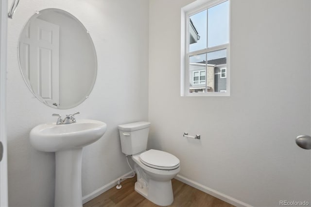 1242 Penner Dr, Erie, CO 80026 - bathroom with baseboards, toilet, a sink, and wood finished floors