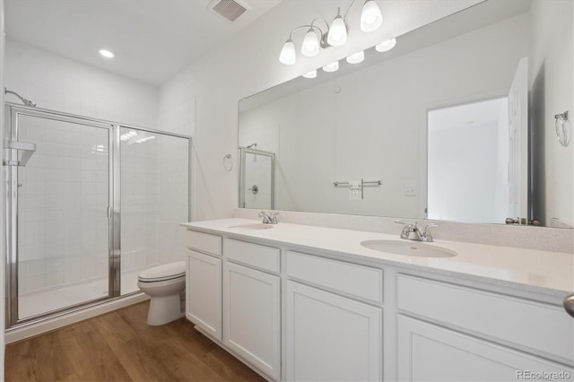 1242 Penner Dr, Erie, CO 80026 - bathroom featuring visible vents, a shower stall, toilet, wood finished floors, and a sink