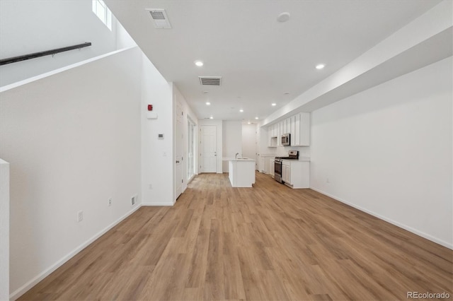 1242 Penner Dr, Erie, CO 80026 - unfurnished living room featuring baseboards, visible vents, recessed lighting, and light wood-type flooring