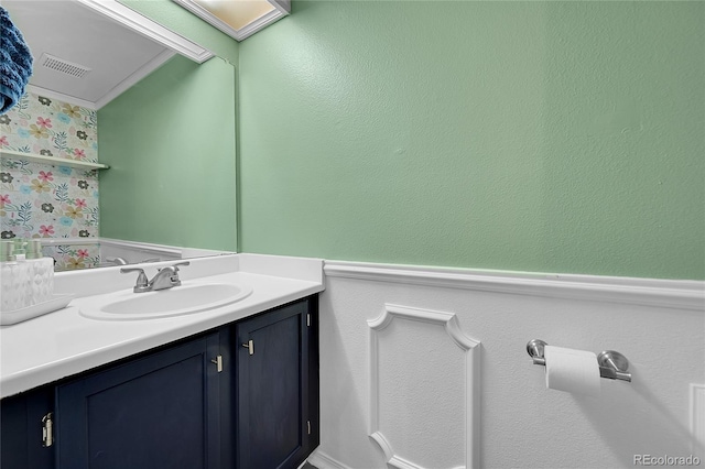 bathroom with a wainscoted wall, vanity, and visible vents