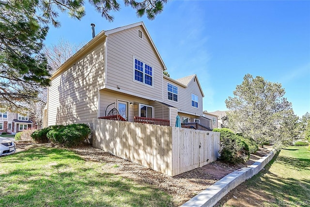 back of property with fence and a yard