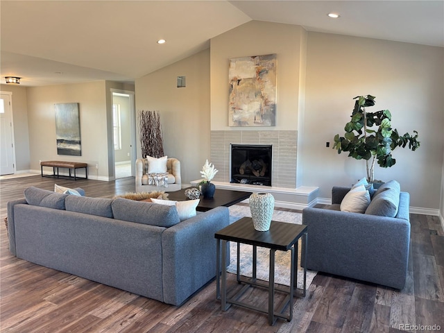 living room featuring a tile fireplace, lofted ceiling, and dark hardwood / wood-style floors