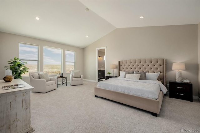 bedroom featuring ensuite bathroom, lofted ceiling, and light colored carpet