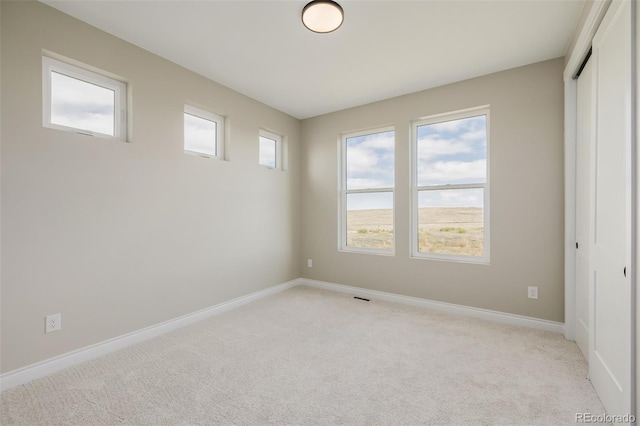 unfurnished bedroom featuring a closet and light carpet