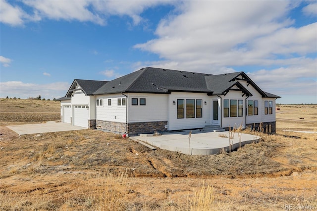 back of house with a garage and a patio