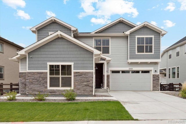 craftsman inspired home with stone siding, concrete driveway, an attached garage, and a front lawn