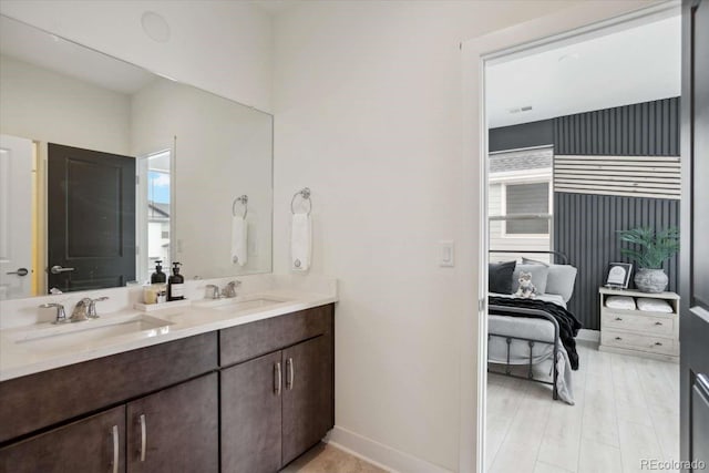 bathroom featuring double vanity, healthy amount of natural light, and baseboards