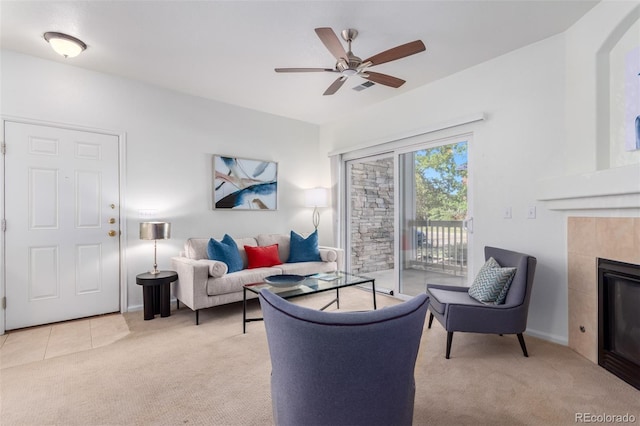 living room with a fireplace, light colored carpet, and ceiling fan