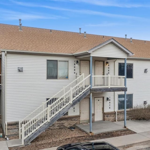 18084 Becket Dr, Parker, CO 80134 - view of front of property featuring a patio, stairs, a shingled roof, and brick siding