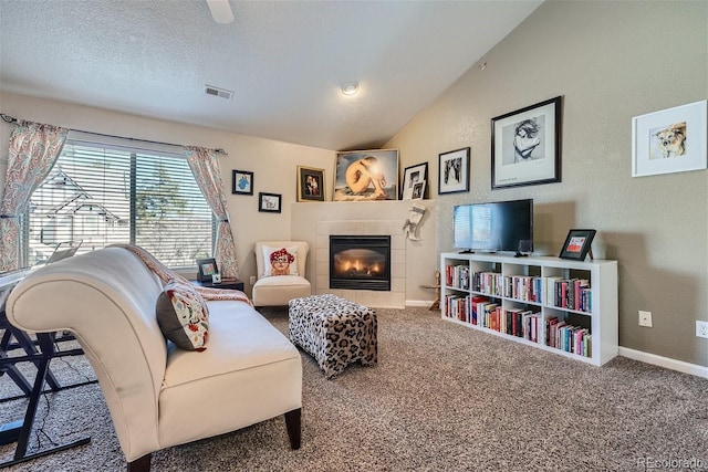 18084 Becket Dr, Parker, CO 80134 - living area featuring a tiled fireplace, vaulted ceiling, carpet, and a textured ceiling