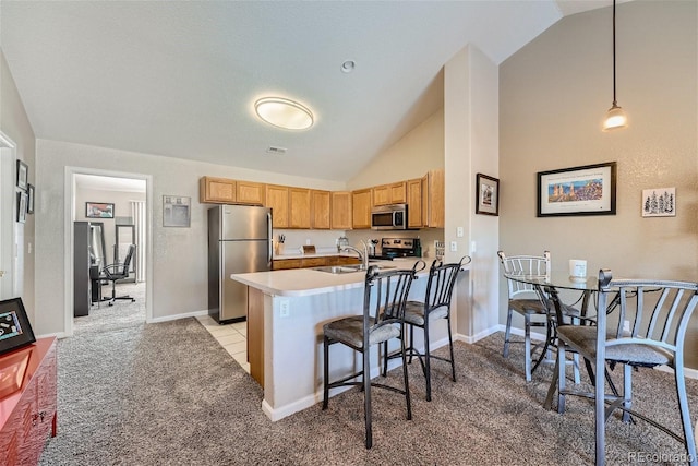 18084 Becket Dr, Parker, CO 80134 - kitchen featuring appliances with stainless steel finishes, vaulted ceiling, light carpet, a kitchen breakfast bar, and decorative light fixtures