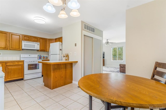 7887 York St Unit 1, Denver, CO 80229 - kitchen featuring white appliances, a chandelier, a peninsula, light countertops, and light tile patterned floors