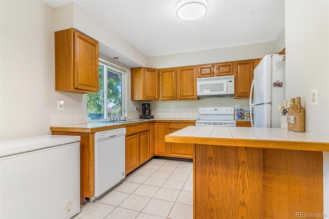 7887 York St Unit 1, Denver, CO 80229 - kitchen with white appliances, tile counters, a peninsula, and brown cabinets