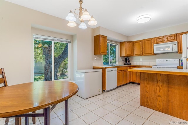 7887 York St Unit 1, Denver, CO 80229 - kitchen featuring white appliances, light countertops, a chandelier, and healthy amount of natural light
