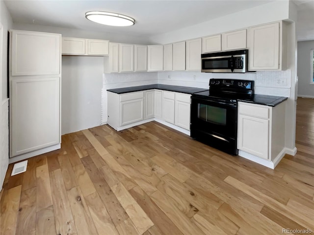 kitchen with electric range, white cabinetry, and light hardwood / wood-style floors