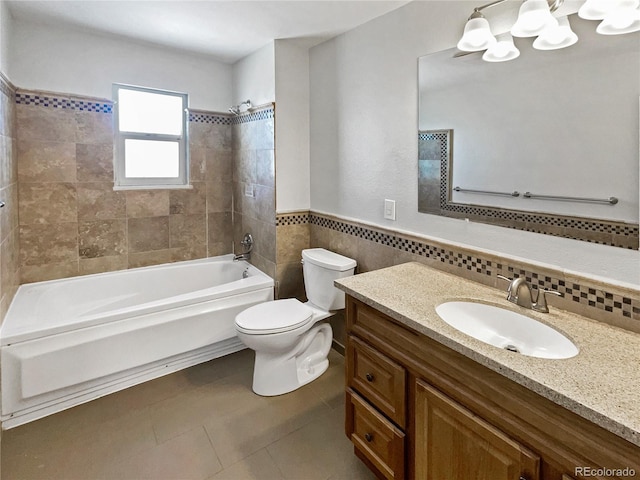 full bathroom with toilet, tiled shower / bath combo, tile patterned flooring, tile walls, and vanity