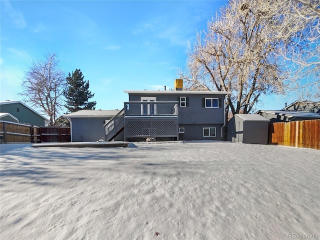 rear view of property featuring a storage shed and a deck