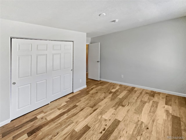 unfurnished bedroom featuring light hardwood / wood-style floors and a closet