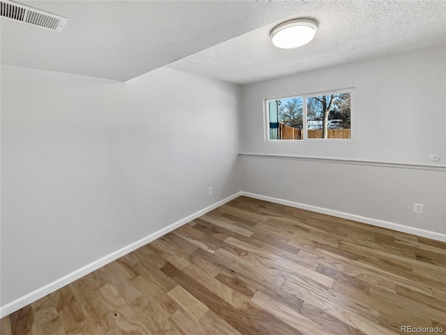 empty room featuring hardwood / wood-style floors and a textured ceiling