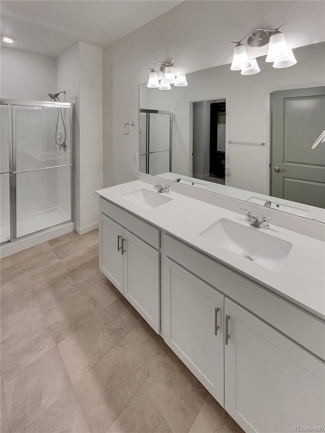 full bath with a stall shower, a sink, and double vanity