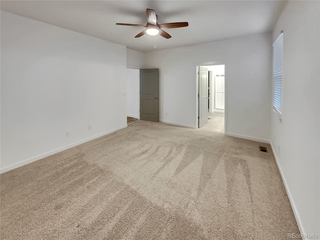 unfurnished room featuring light colored carpet, visible vents, and baseboards