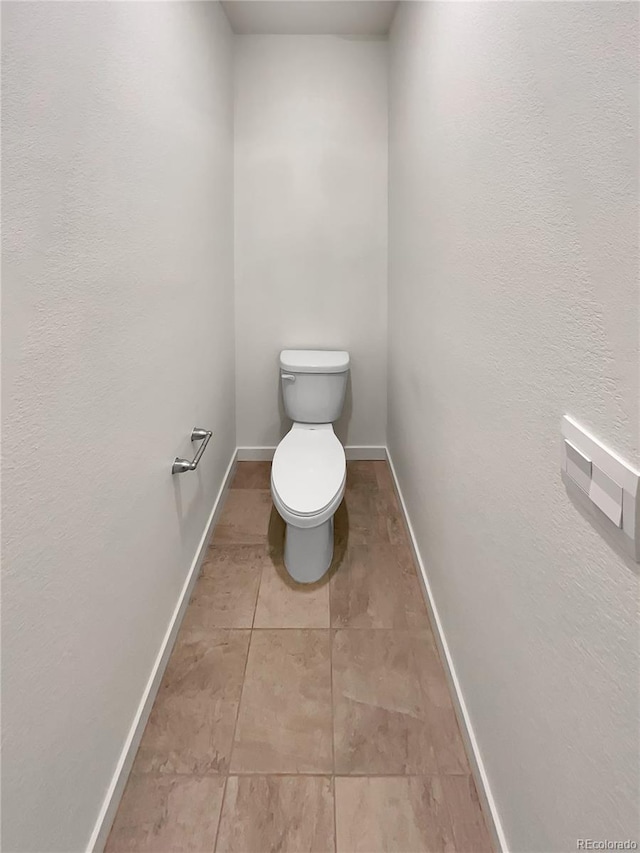 bathroom with toilet and baseboards