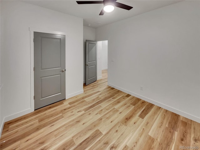 unfurnished bedroom with baseboards, a ceiling fan, and light wood-style floors