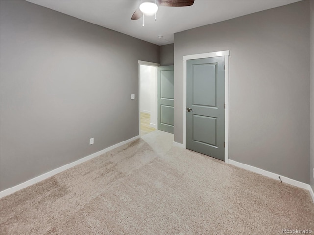 unfurnished bedroom with light colored carpet, ceiling fan, and baseboards