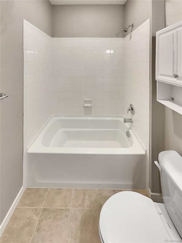 bathroom with toilet, baseboards, tub / shower combination, and tile patterned floors