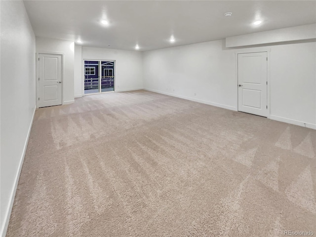 unfurnished room featuring recessed lighting, light carpet, and baseboards