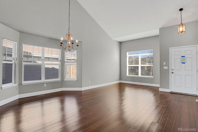 entryway with dark hardwood / wood-style floors, high vaulted ceiling, and a notable chandelier