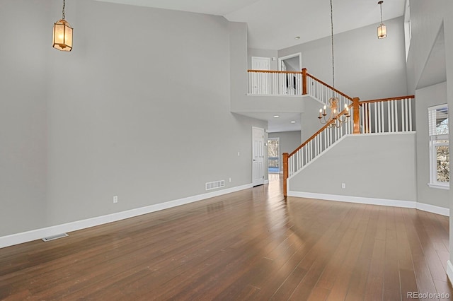 unfurnished living room with hardwood / wood-style floors and high vaulted ceiling