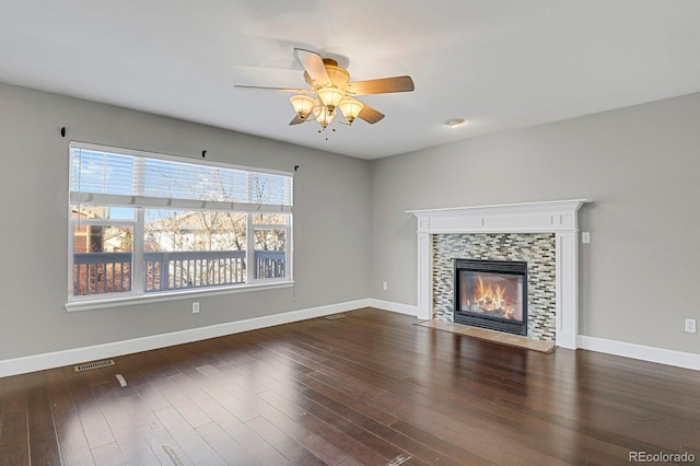 unfurnished living room featuring a fireplace, ceiling fan, and dark wood-type flooring