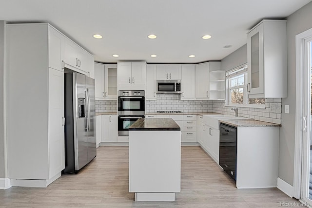 kitchen with white cabinets, stainless steel appliances, and a kitchen island