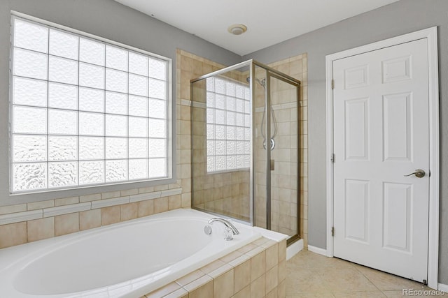 bathroom with tile patterned floors and shower with separate bathtub