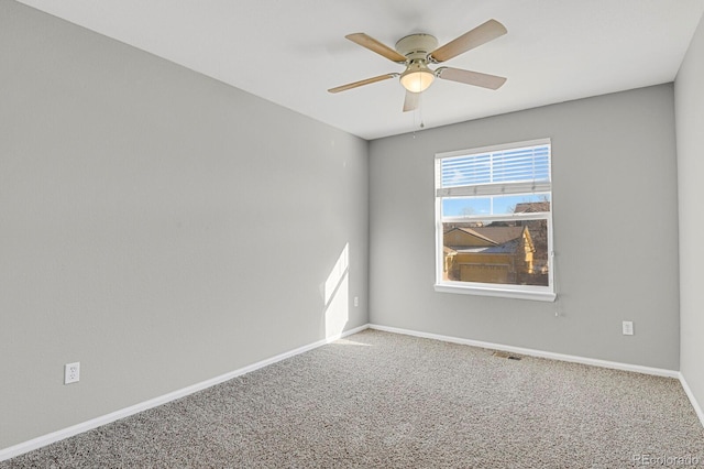 carpeted spare room featuring ceiling fan