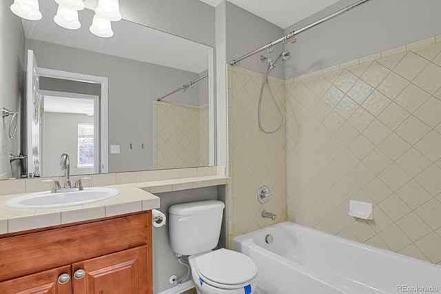 full bathroom with vanity, toilet, and tiled shower / bath