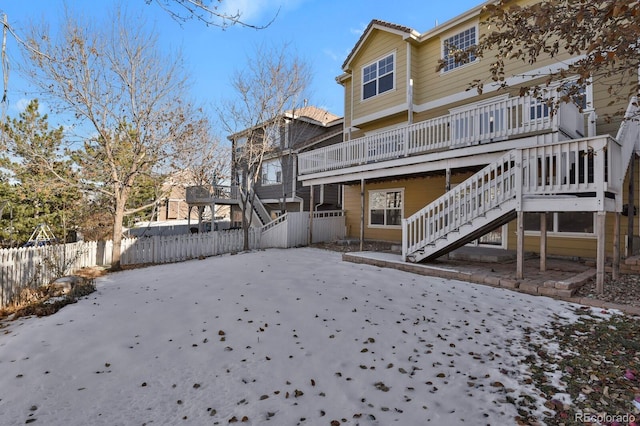 snow covered house featuring a deck