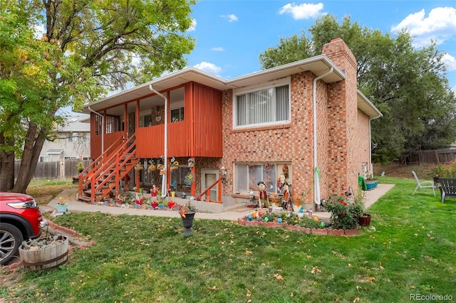 rear view of house featuring a yard and a patio