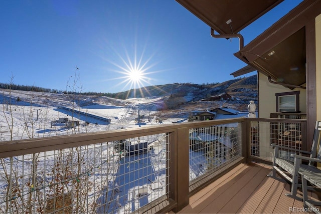 snow covered deck featuring a mountain view