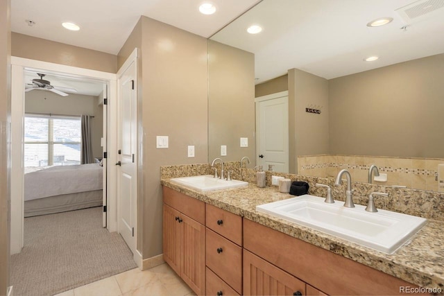 ensuite bathroom featuring recessed lighting, visible vents, a sink, and double vanity