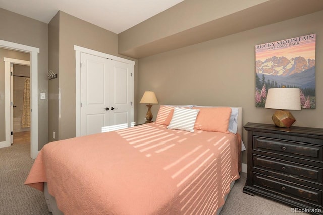 carpeted bedroom featuring a closet and baseboards