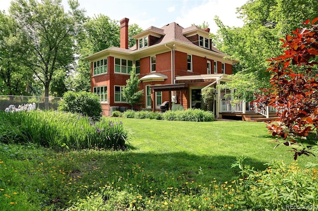 rear view of house featuring a lawn