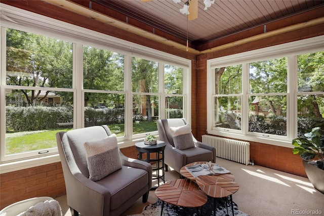 sunroom / solarium featuring radiator heating unit and wood ceiling