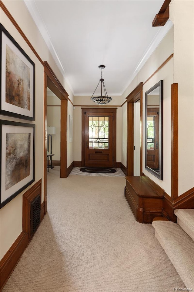 carpeted entrance foyer featuring crown molding