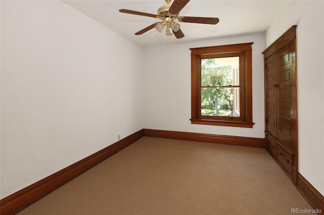 empty room featuring ceiling fan and light colored carpet